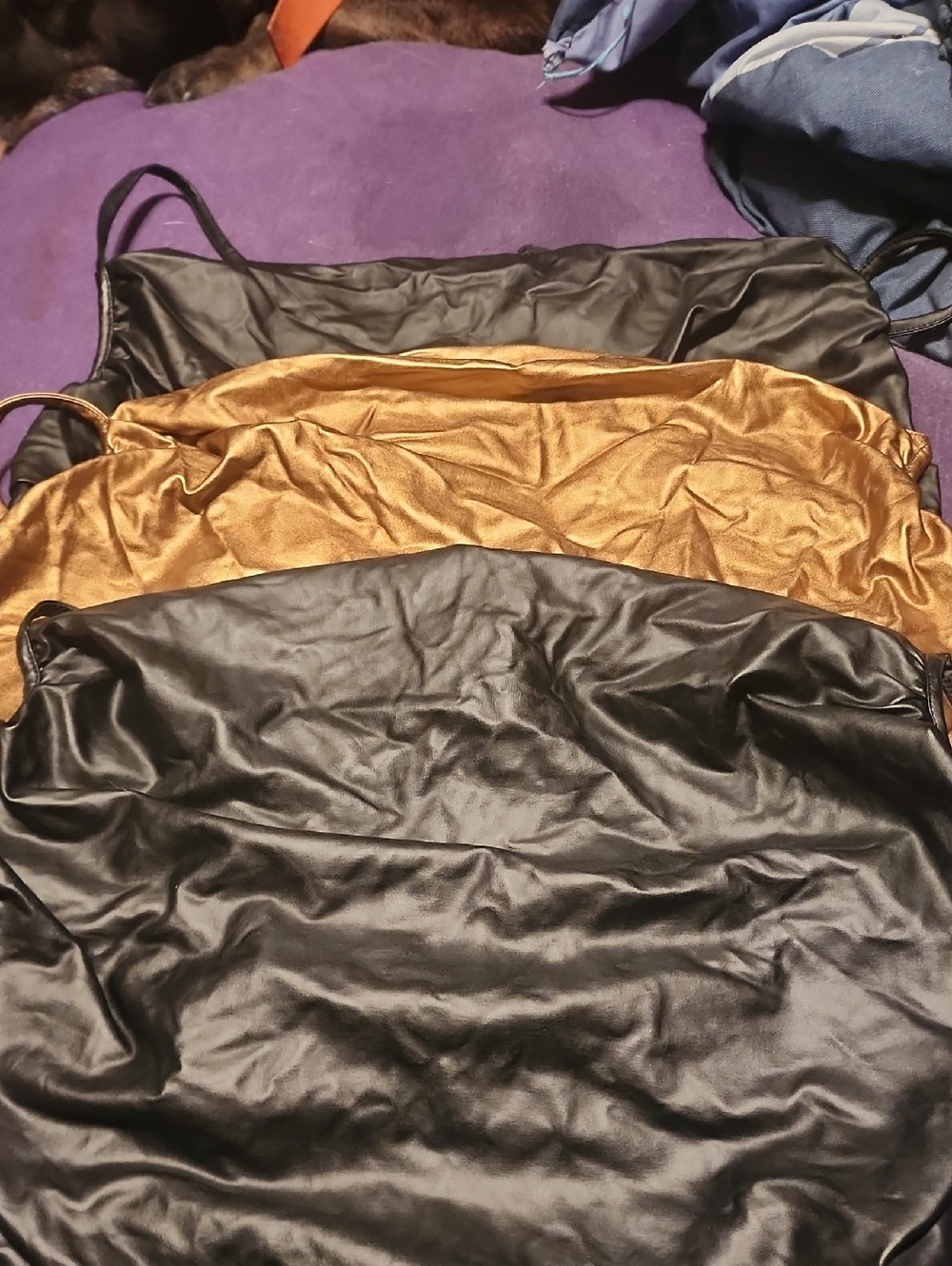 A Trio Of Black and Gold Satin Body Suits